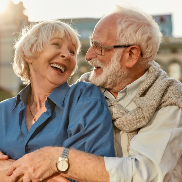Feeling happy with you. Cheerful senior couple in casual clothing embracing each other and laughing while standing together outdoors
